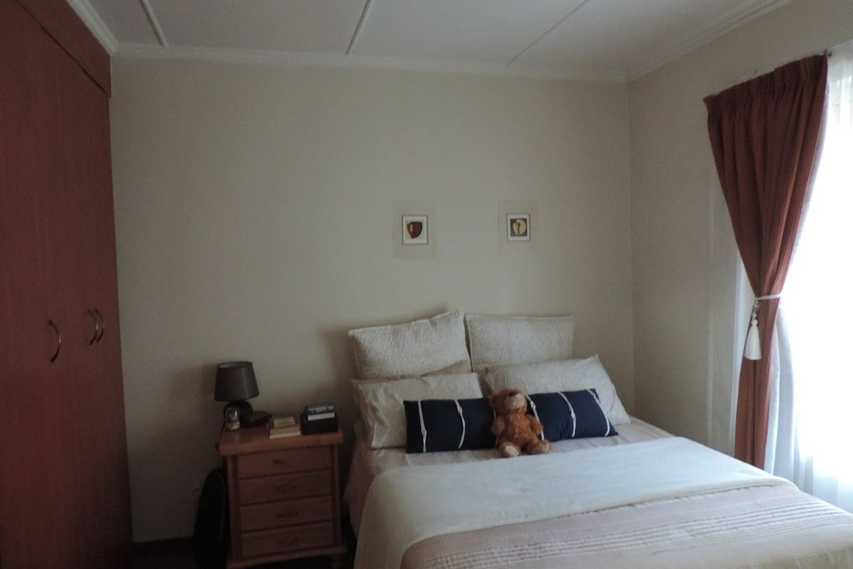 A functional bedroom featuring a built-in wardrobe and ceiling panel detailing, offering a comfortable and well-maintained living space.