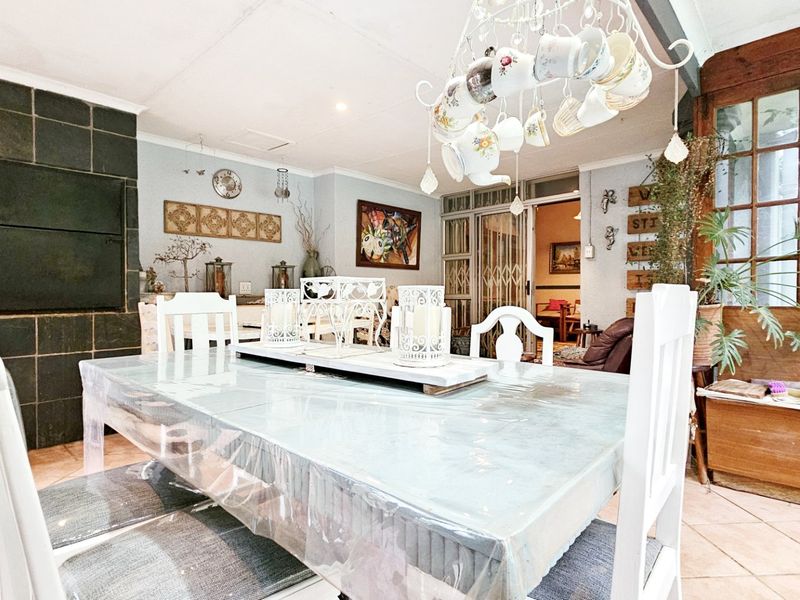 Dining area featuring tiled flooring, a built-in fireplace, and timber-framed windows, providing a functional space for family meals.