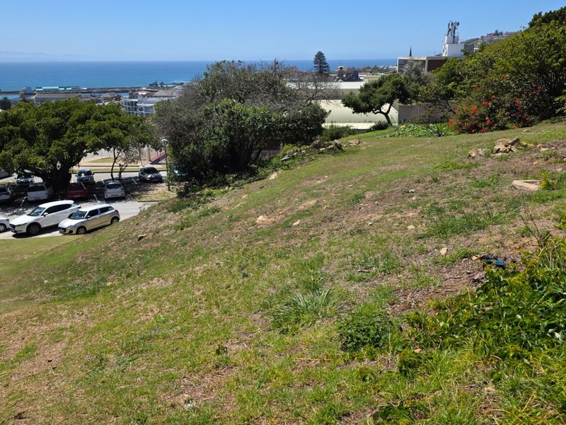 A view of the sloped residential land overlooking the coastal area and nearby parking facilities.