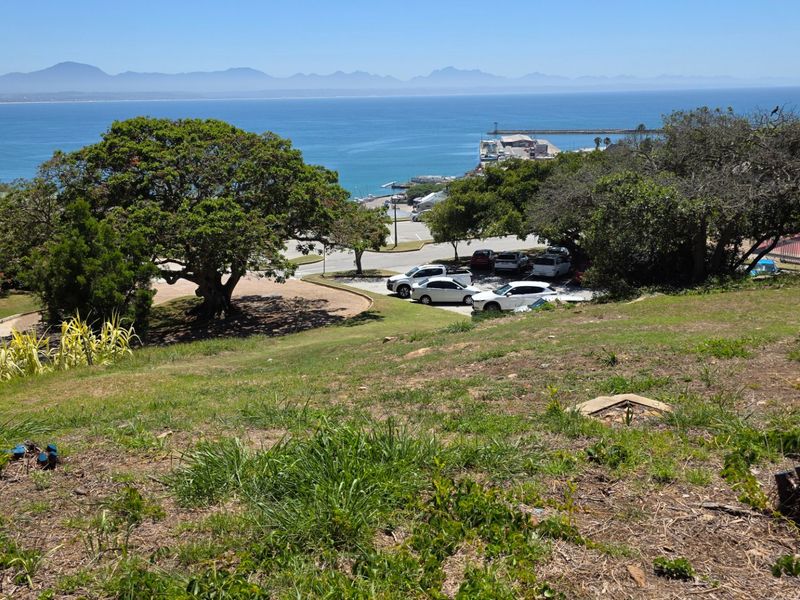 Elevated view overlooking the coastline, harbour, and distant mountain range from the residential land plot.