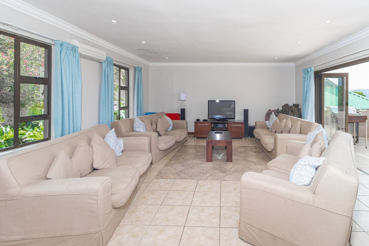 Spacious living room featuring tiled flooring, crown molding, recessed lighting, and direct access to the outdoor area through sliding glass doors.