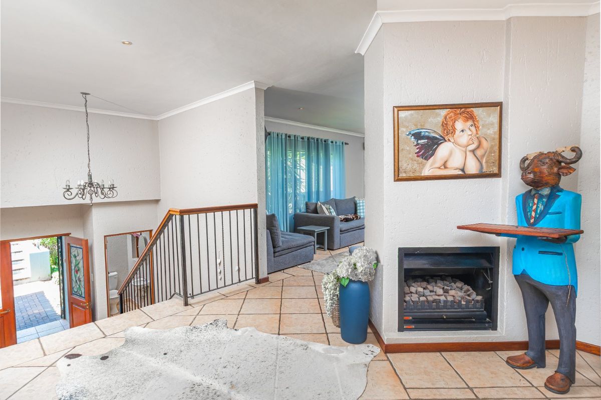 Spacious living area featuring a built-in fireplace, ceramic tile flooring, and an open staircase leading to the lower level.