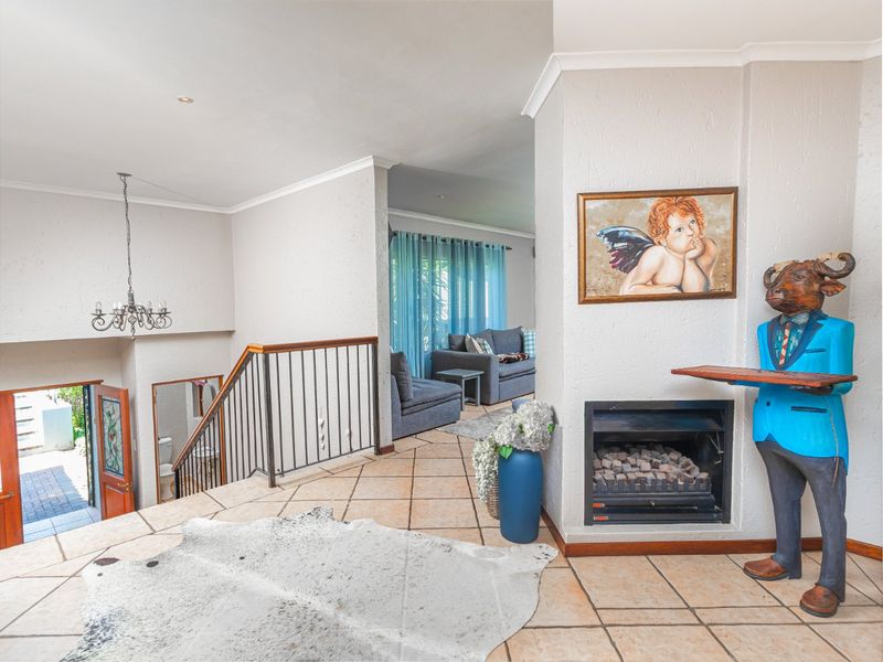 Spacious living area featuring a built-in fireplace, ceramic tile flooring, and an open staircase leading to the lower level.