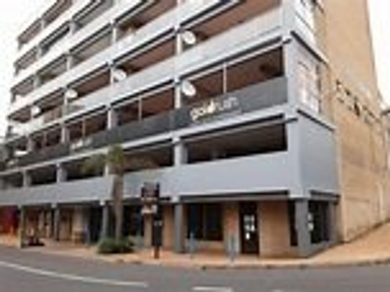 Multi-story commercial building facade featuring ground-level retail space and upper-level balconies with street-front access.