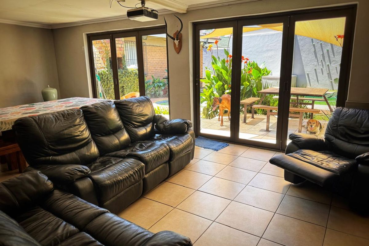 Spacious living area featuring large glass sliding doors that provide seamless access to the outdoor patio and garden area.