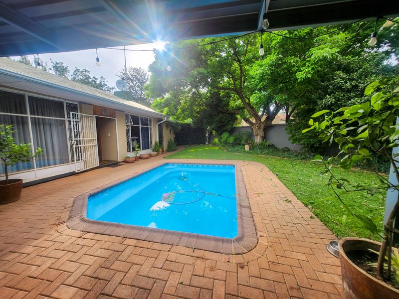 A cozy and inviting 4-bedroom, 3-bathroom family home with a huge scullery, sparkling pool, entertainment area with built-in braai, neat irrigated garden, double garage, and ample parking for all your needs. - Photo 6