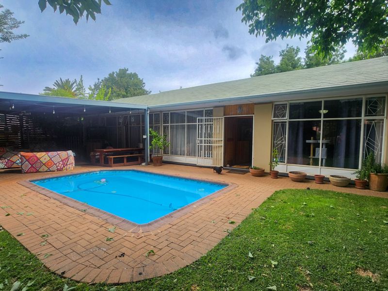 A cozy and inviting 4-bedroom, 3-bathroom family home with a huge scullery, sparkling pool, entertainment area with built-in braai, neat irrigated garden, double garage, and ample parking for all your needs. - Photo 4