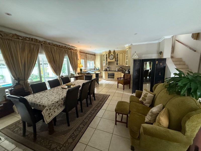Spacious open-plan living and dining area featuring tiled floors, a functional kitchen with built-in cabinetry, and direct access to the outdoor patio area.