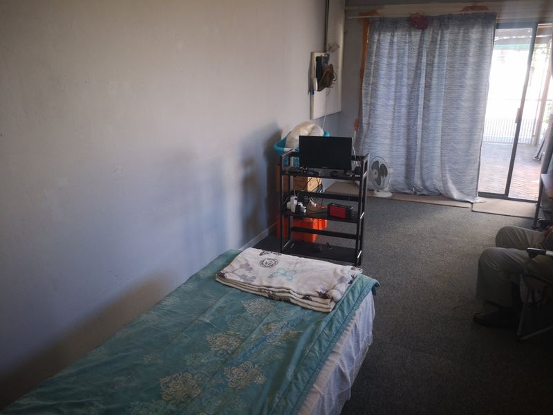 A bedroom featuring carpeted flooring and a sliding glass door providing access to the exterior.