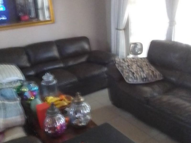 A living room area featuring tiled flooring and natural light from the window.
