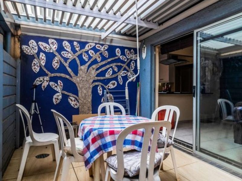 Covered patio area featuring a decorative mosaic wall mural and sliding glass door access to the interior living space.