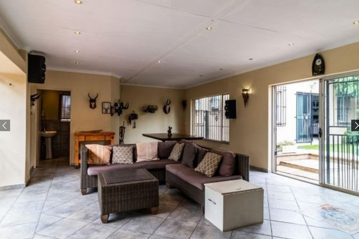 Spacious living area featuring tiled flooring, recessed ceiling lighting, and large sliding glass doors providing direct access to the outdoor patio.
