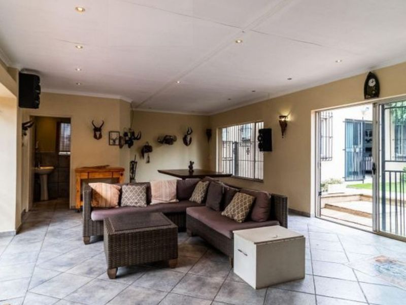 Spacious living area featuring tiled flooring, recessed ceiling lighting, and large sliding glass doors providing direct access to the outdoor patio.