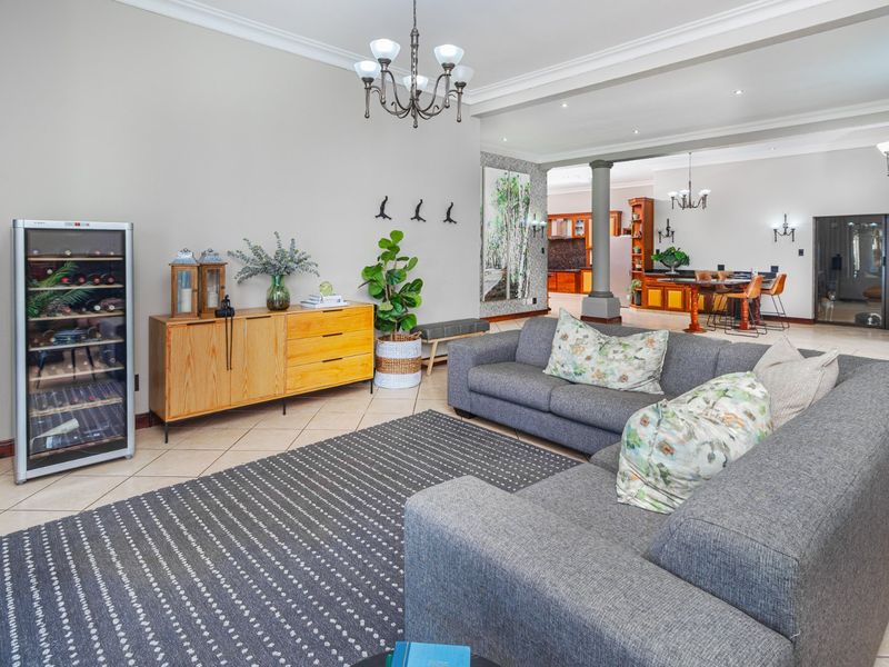 Spacious open-plan living area featuring tiled floors, crown molding, and a seamless transition to the kitchen and dining space.