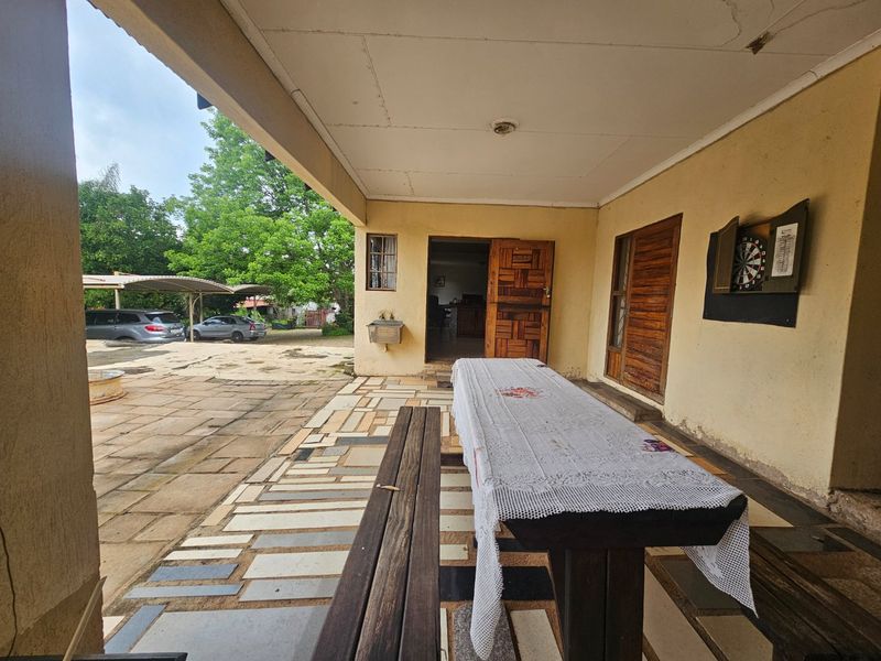 A covered outdoor patio area featuring paved flooring, an exterior tap, and direct access to the main dwelling.
