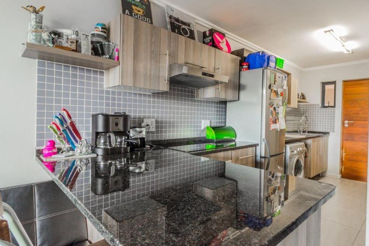 A functional kitchen featuring granite countertops, tiled backsplash, and ample built-in cabinetry, providing a practical workspace for daily cooking and meal preparation.