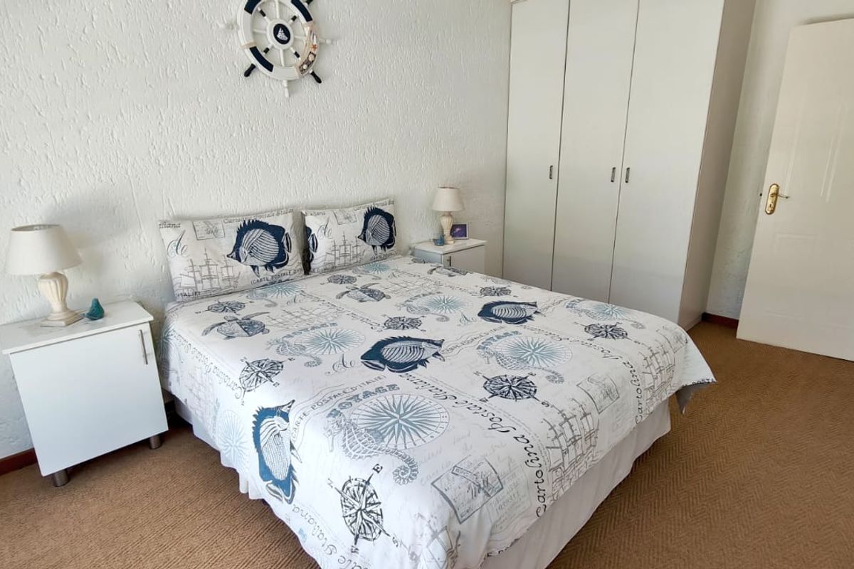 A functional bedroom featuring neutral carpet flooring and a built-in wardrobe, providing practical storage space.