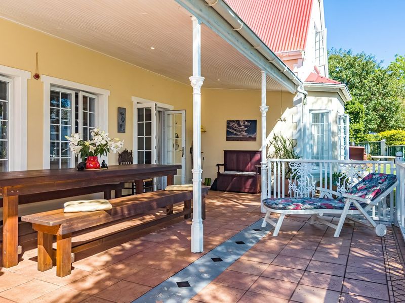 A spacious covered patio featuring tiled flooring, decorative metal columns, and direct access to the home through multiple sets of french doors.