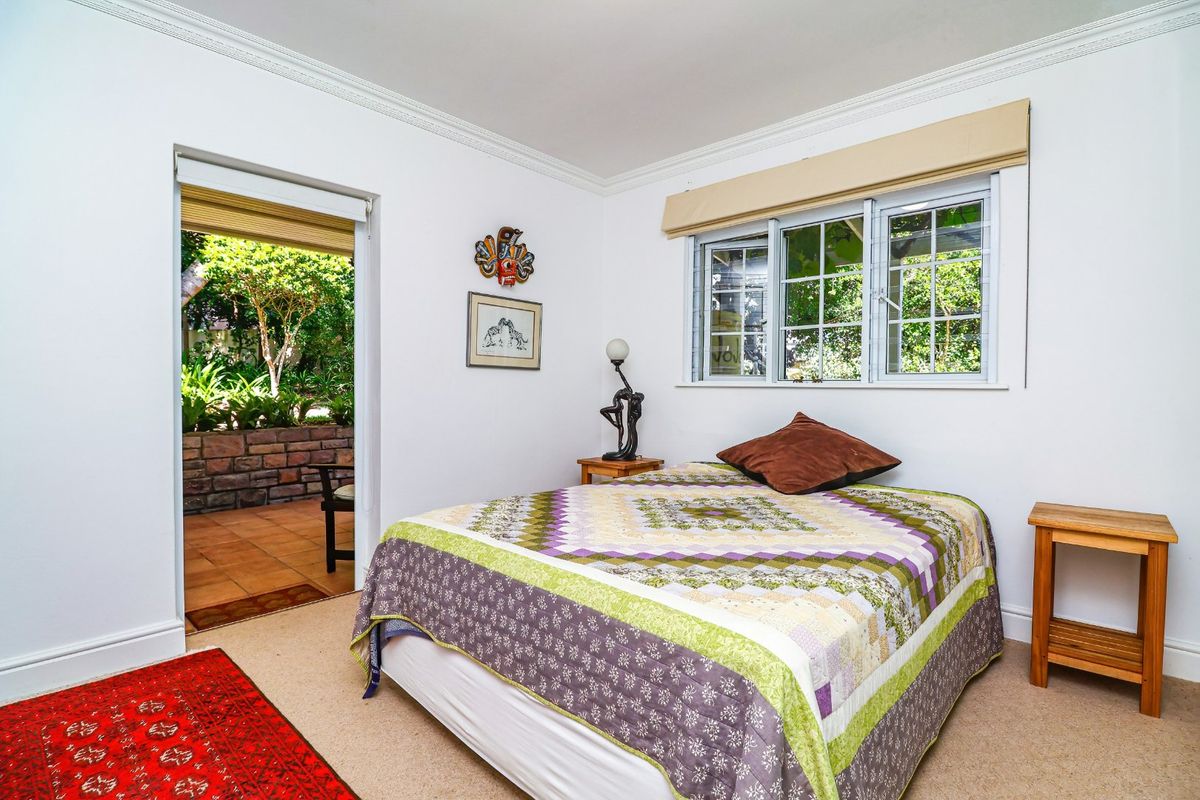 A bedroom featuring neutral walls, crown molding, and direct access to an outdoor patio area through a doorway.