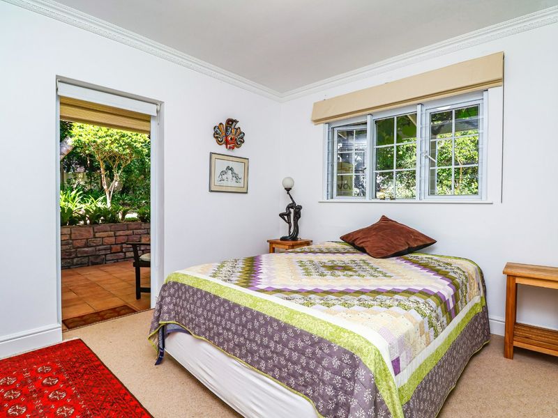 A bedroom featuring neutral walls, crown molding, and direct access to an outdoor patio area through a doorway.