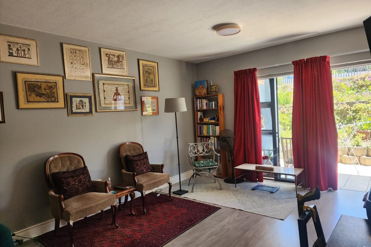A comfortable living room featuring laminate flooring and a large sliding glass door that provides access to an outdoor patio area.