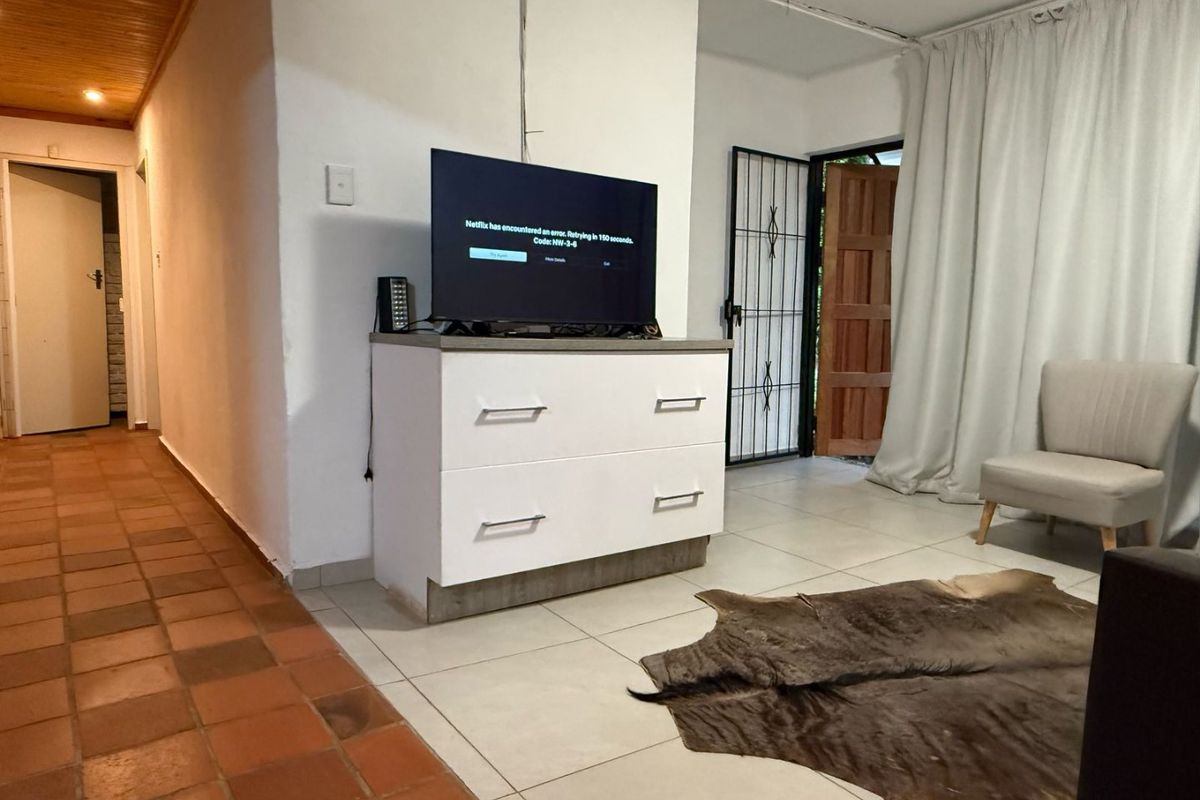 Living area featuring tiled flooring, a timber ceiling, and direct access to an exterior security gate.