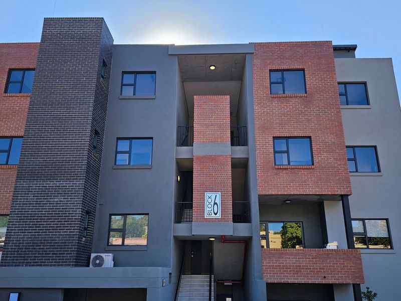 Modern multi-story townhouse block featuring a contemporary brick and plaster facade with aluminium window frames and integrated stairwell access.