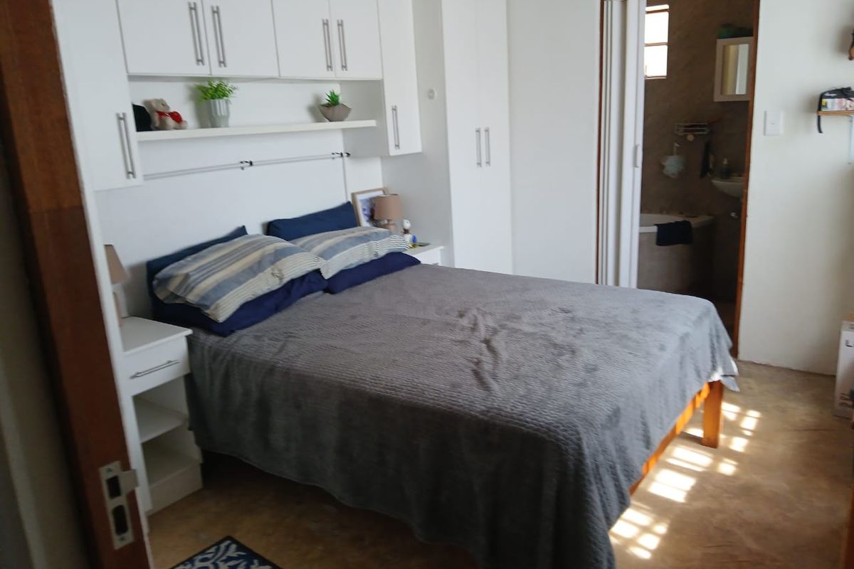 A bedroom featuring built-in cupboards with overhead storage and direct access to an en-suite bathroom.