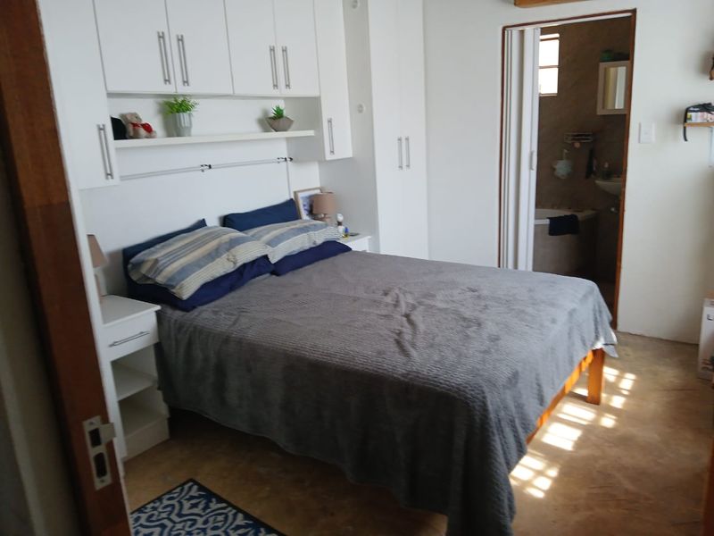 A bedroom featuring built-in cupboards with overhead storage and direct access to an en-suite bathroom.