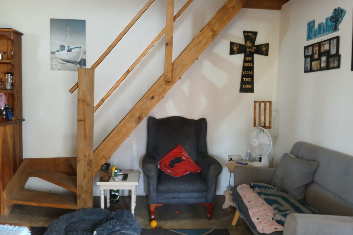 A living area featuring a wooden staircase and neutral wall finishes, providing a functional space for relaxation.