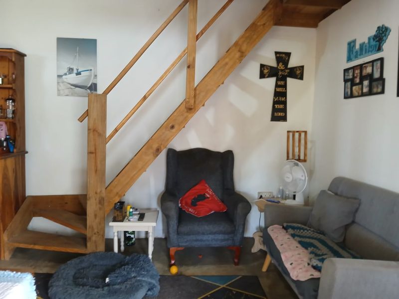 A living area featuring a wooden staircase and neutral wall finishes, providing a functional space for relaxation.
