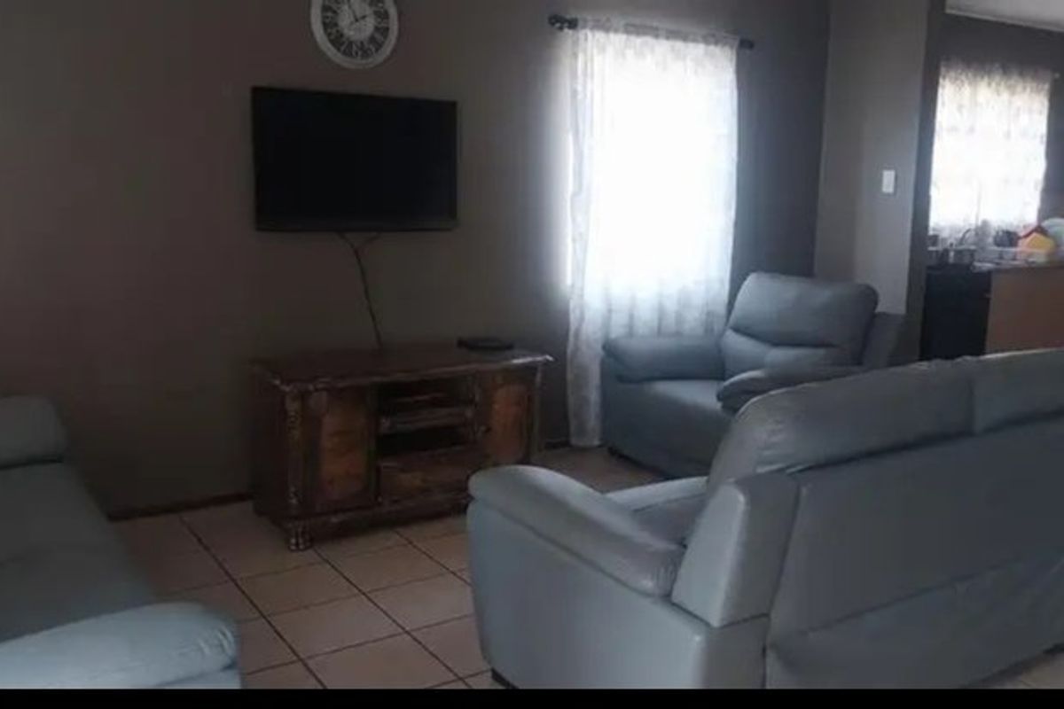 A living room area featuring tiled flooring and neutral wall tones, providing a functional space for relaxation.