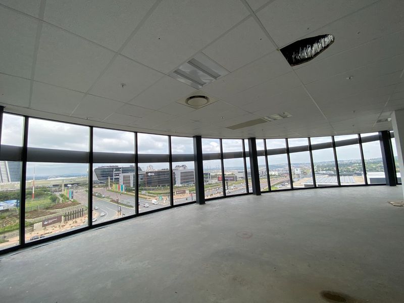 Open-plan commercial office space featuring expansive floor-to-ceiling windows with panoramic views, requiring ceiling repairs and interior fit-out.