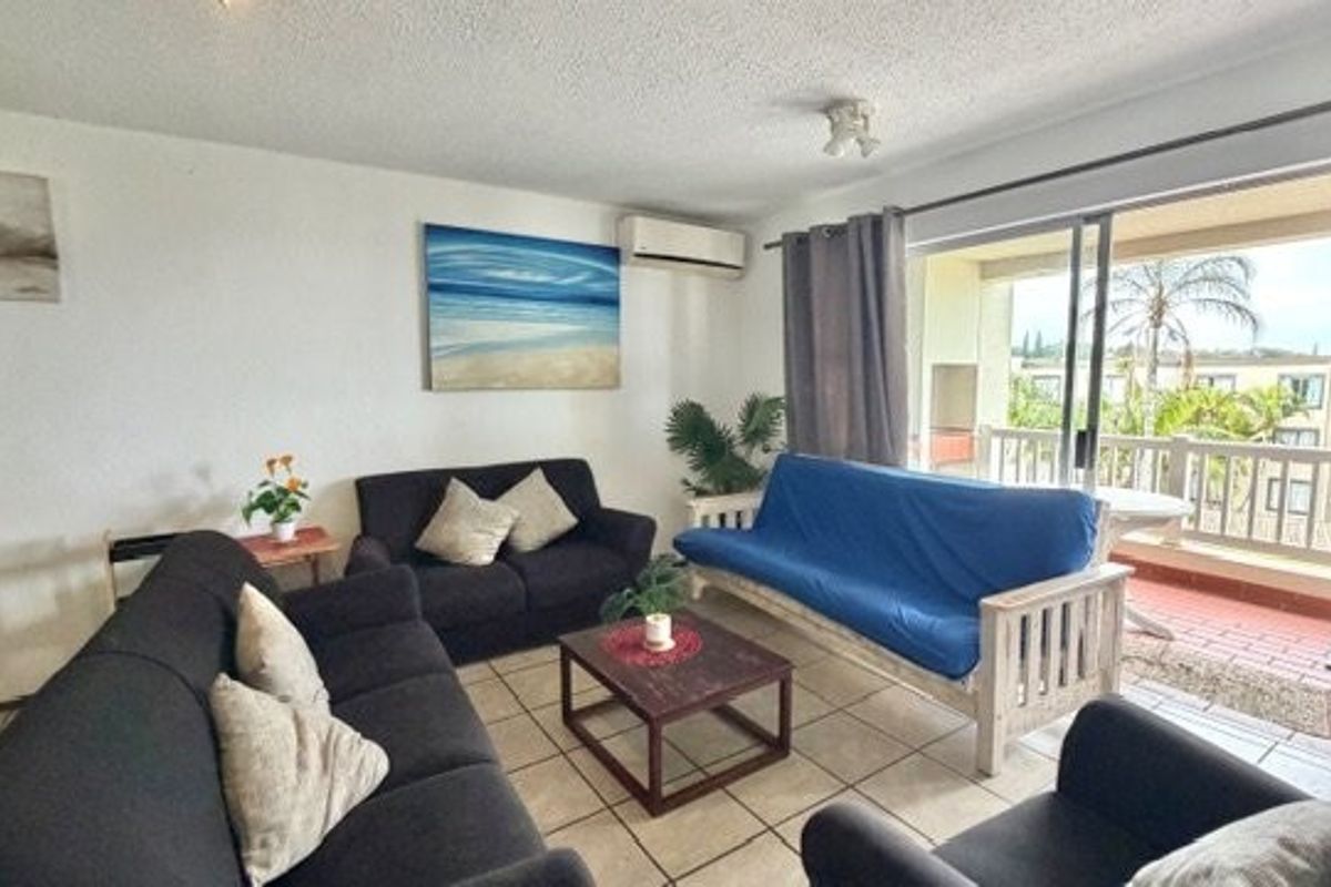 A living room featuring tiled flooring, a split-system air conditioner, and a sliding glass door providing access to an outdoor balcony area.