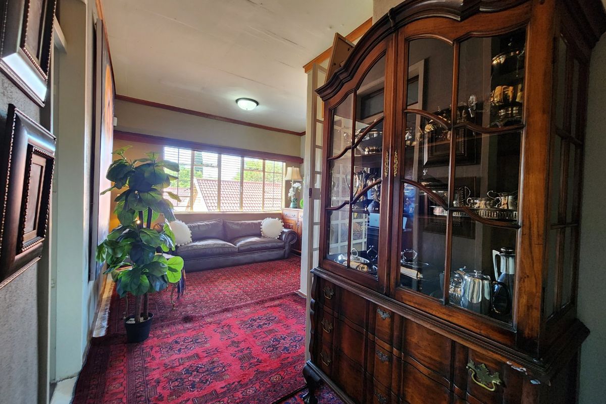 A view of a living area featuring large windows, traditional wood trim, and a spacious layout suitable for a commercial office or reception space.