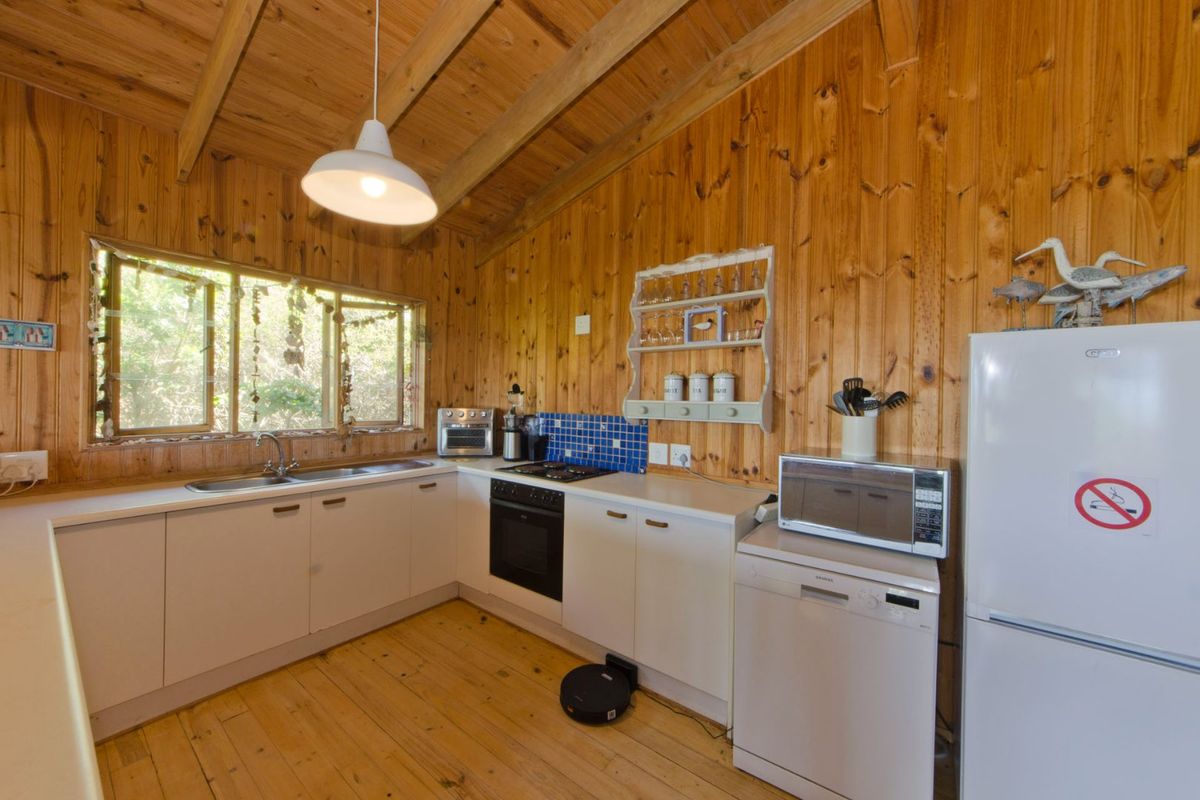 Kitchen featuring timber wall paneling, exposed rafters, timber flooring, built-in cabinetry, and a gas hob with tiled splashback.