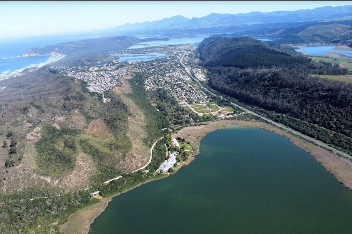 An aerial view showing the coastal landscape, surrounding lake, and regional road infrastructure.