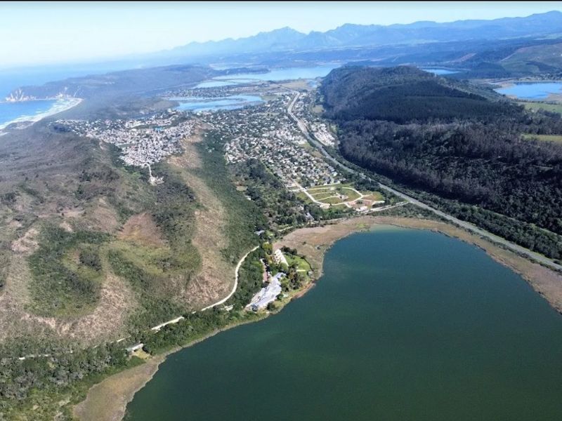 An aerial view showing the coastal landscape, surrounding lake, and regional road infrastructure.
