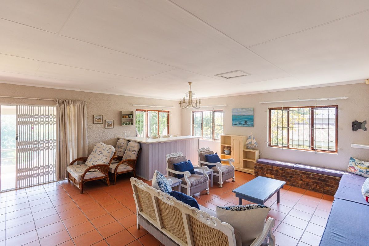 Spacious living room featuring terracotta floor tiles, a built-in bar counter, and a brick bench, offering a versatile layout with ample natural light.