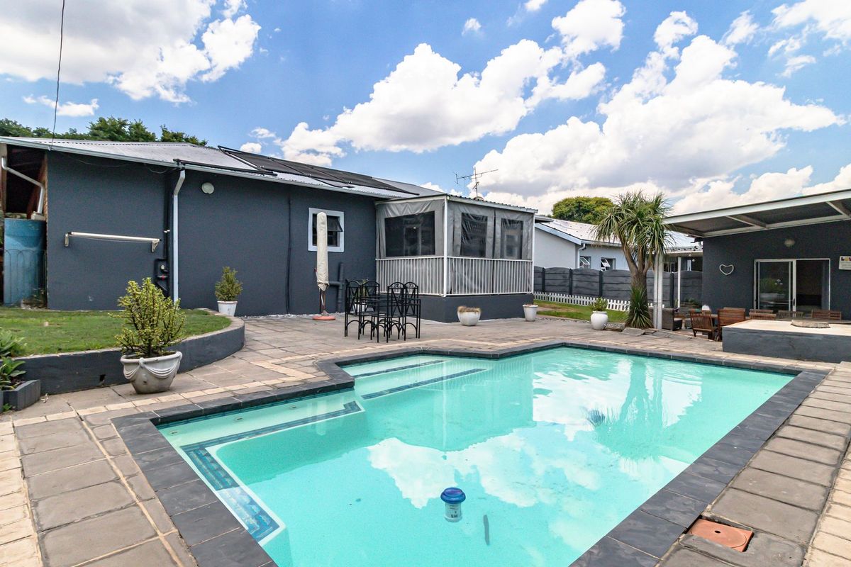 Outdoor pool area featuring a swimming pool, paved patio space, and an enclosed patio structure, ideal for outdoor entertaining.