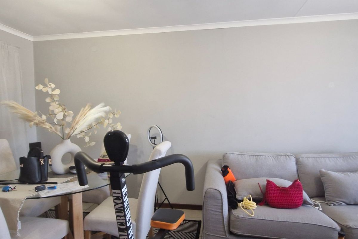A neutrally painted living area featuring cove cornicing, providing a blank canvas for personalized interior design and furniture arrangement.