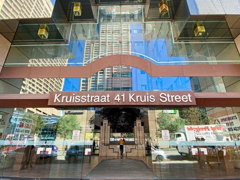 The main entrance facade of the apartment building at 41 Kruis Street, featuring a modern glass and stone exterior design.