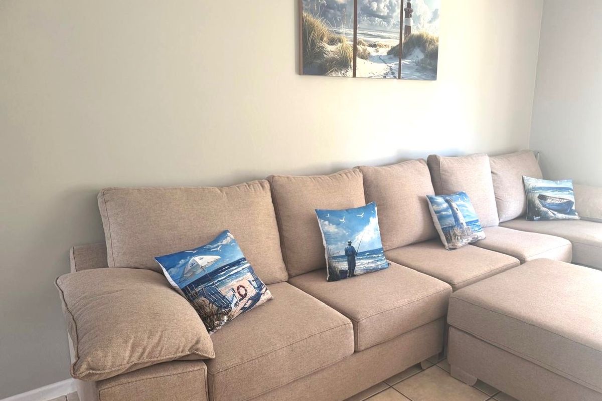 A living room area featuring neutral wall tones and tiled flooring, providing a functional space for relaxation.