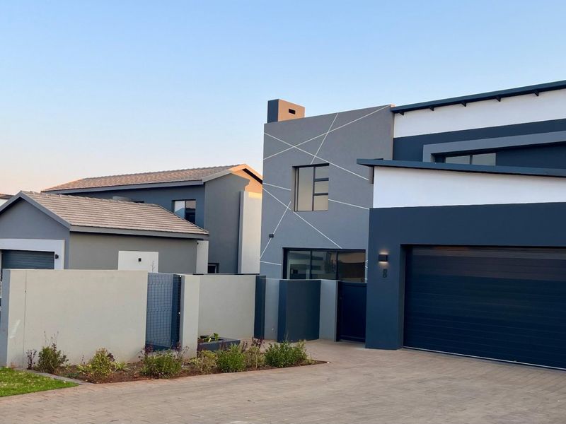 Modern double-story residential property featuring a contemporary facade, paved driveway, and integrated double garage with clean architectural lines.