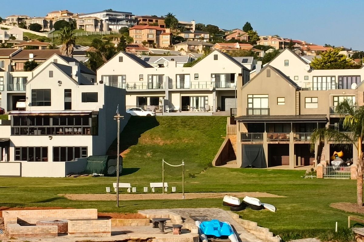 A wide-angle view of a residential estate featuring multi-level homes overlooking a landscaped green space and communal outdoor area.