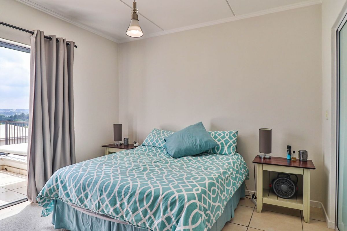 A bedroom featuring tiled flooring and a sliding glass door providing access to an outdoor balcony area.