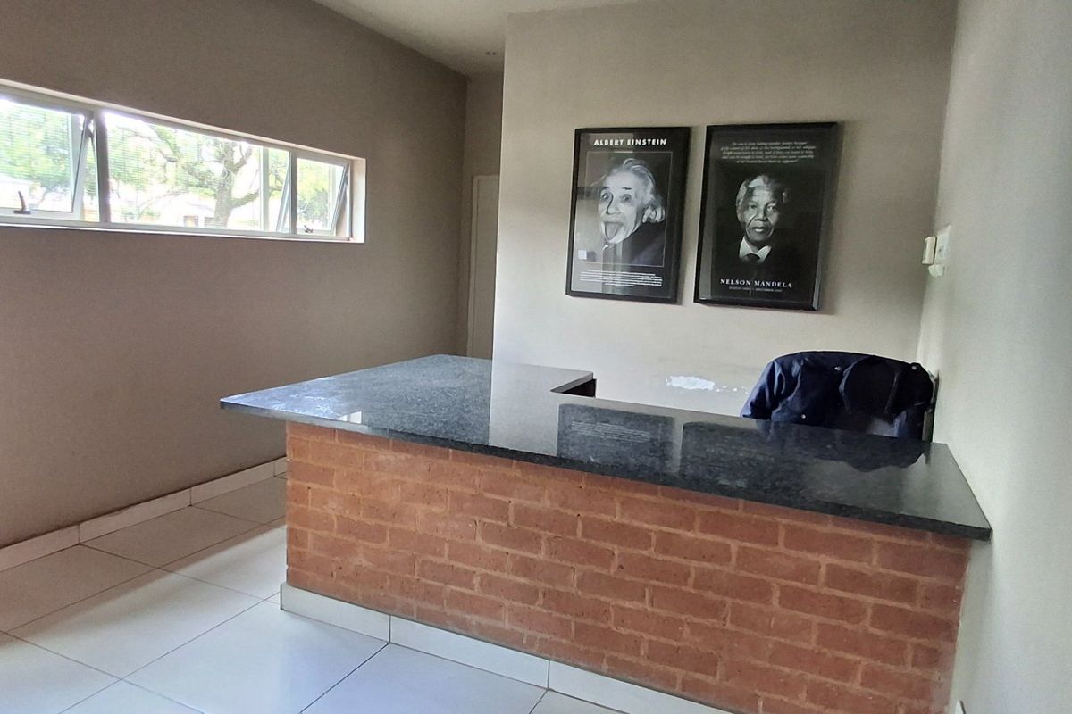 A living area featuring a built-in brick breakfast bar with a granite countertop, tiled flooring, and a horizontal window.