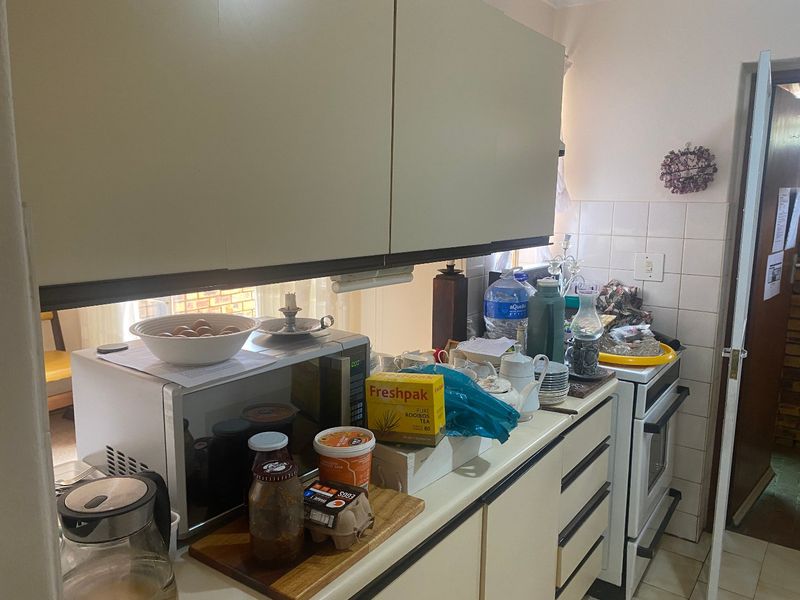 A functional kitchen featuring built-in cabinetry, a tiled backsplash, and a freestanding oven, offering a practical layout for daily meal preparation.