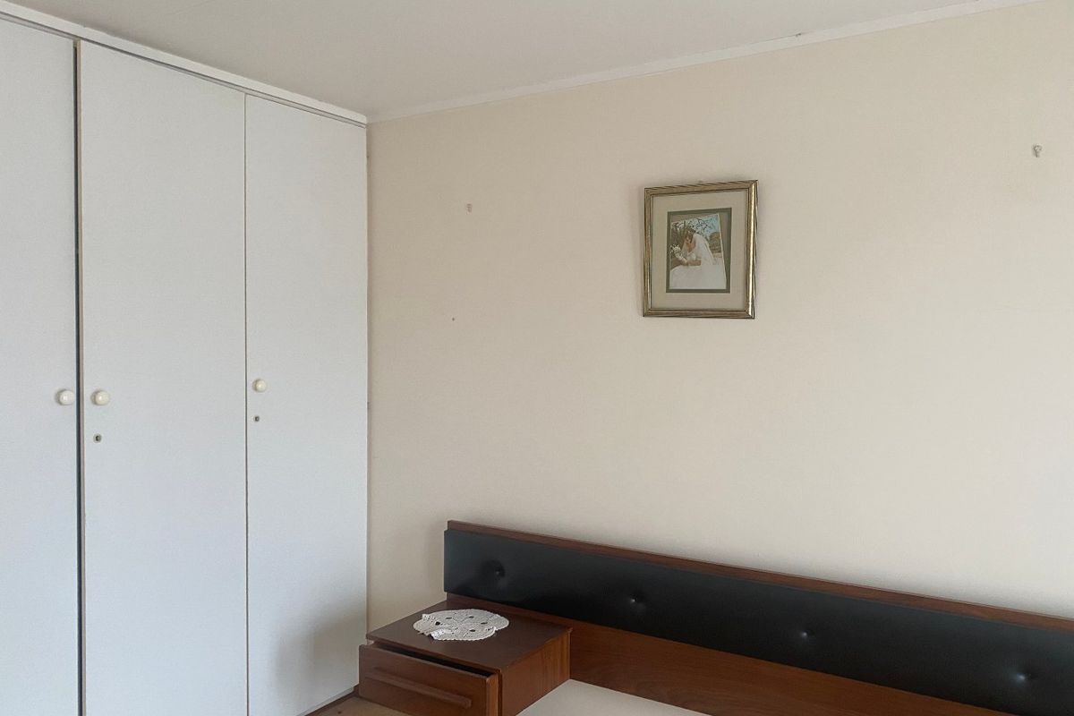 A bedroom featuring a built-in wardrobe with white doors and a neutral wall finish.