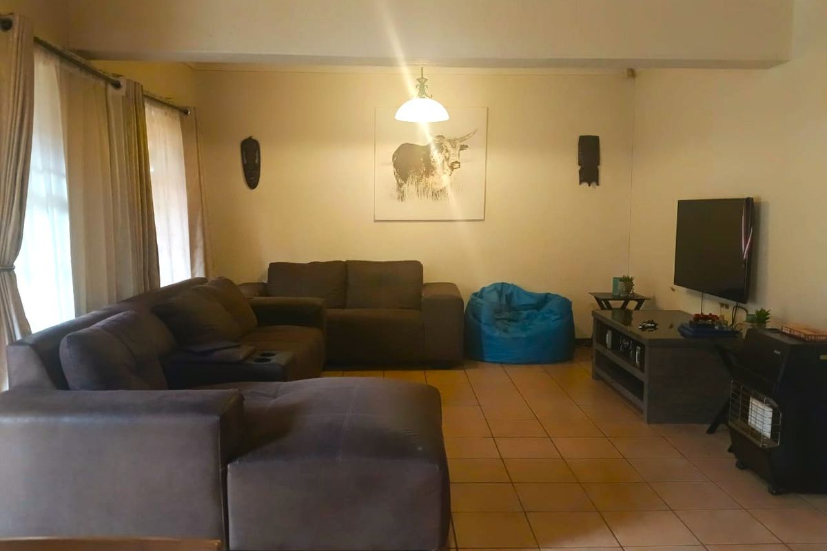 A spacious living room featuring tiled flooring and neutral wall finishes, providing a comfortable and functional area for relaxation.